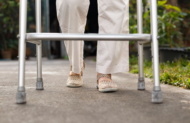 Senior with Walker on Sidwalk